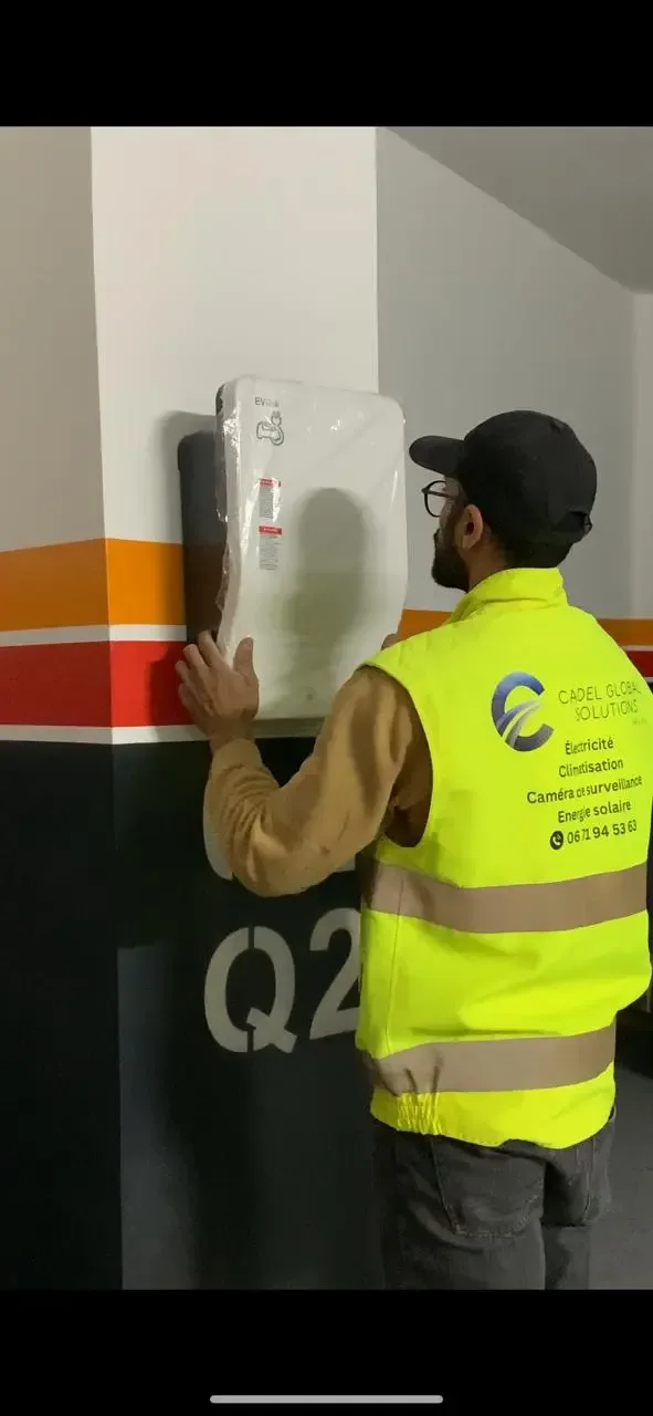Installation professionnelle d'une Wallbox pour véhicule électrique dans une villa à Marrakech par l'équipe technique de CADEL Global Solutions.